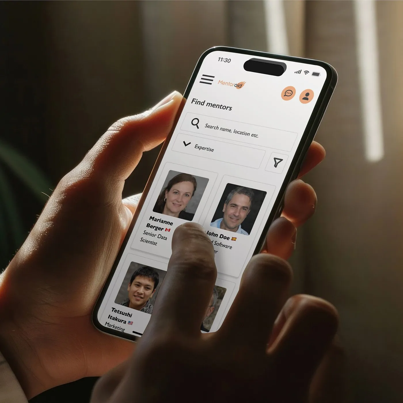 Hand holding a phone showing the Mentoroid find mentors screen
